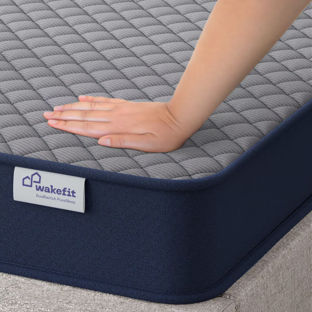 Hand touching a mattress with 'wakefit' branding